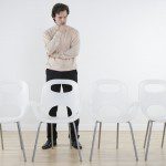 Thinking Businessman Staring at Empty Chairs