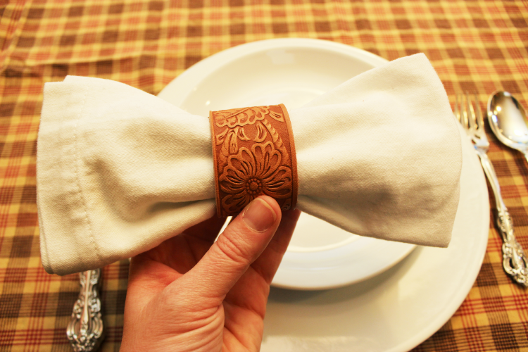 Cloth napkin bow with a DIY leather napkin ring. Simple to make, beautiful addition to your next tablescape. 