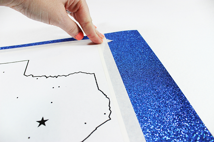 Tape your silhouette template onto your glittery scrapbook paper. 