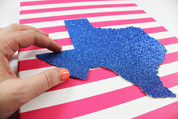 Attach your glittery shape to the canvas with glue dots. 
