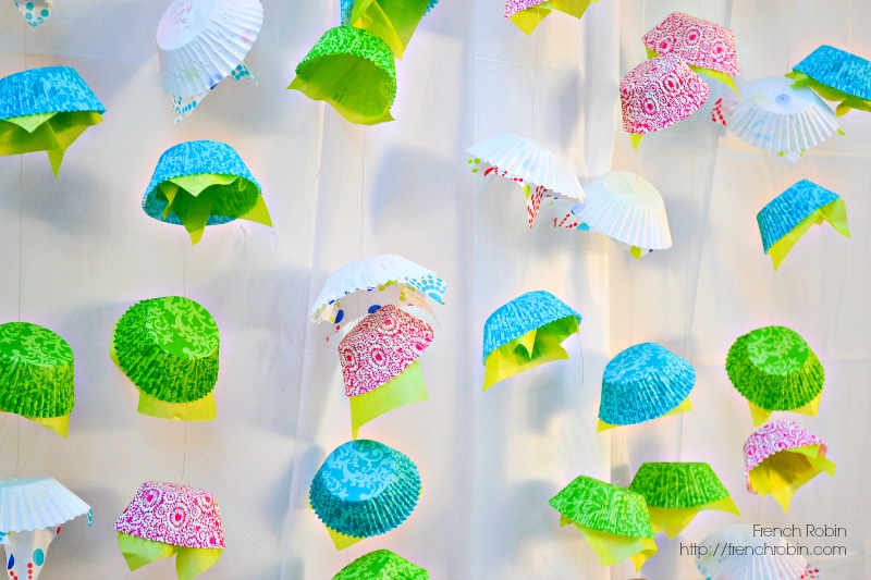 Use fishing line, cupcake liners, and tissue paper to create a fun DIY photo backdrop for your next party. 