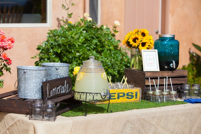 A dedicated table for drinks is a must for an outdoor summer party! I love how the old Pepsi crate looks with the sunflowers and the moss runner. Super cute! 