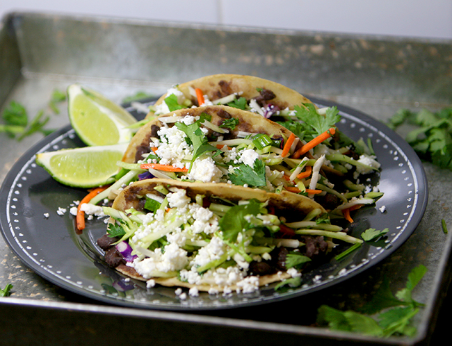 Healthy black bean tacos topped with delicious cilantro lime slaw. They will leave you begging for a second helping!