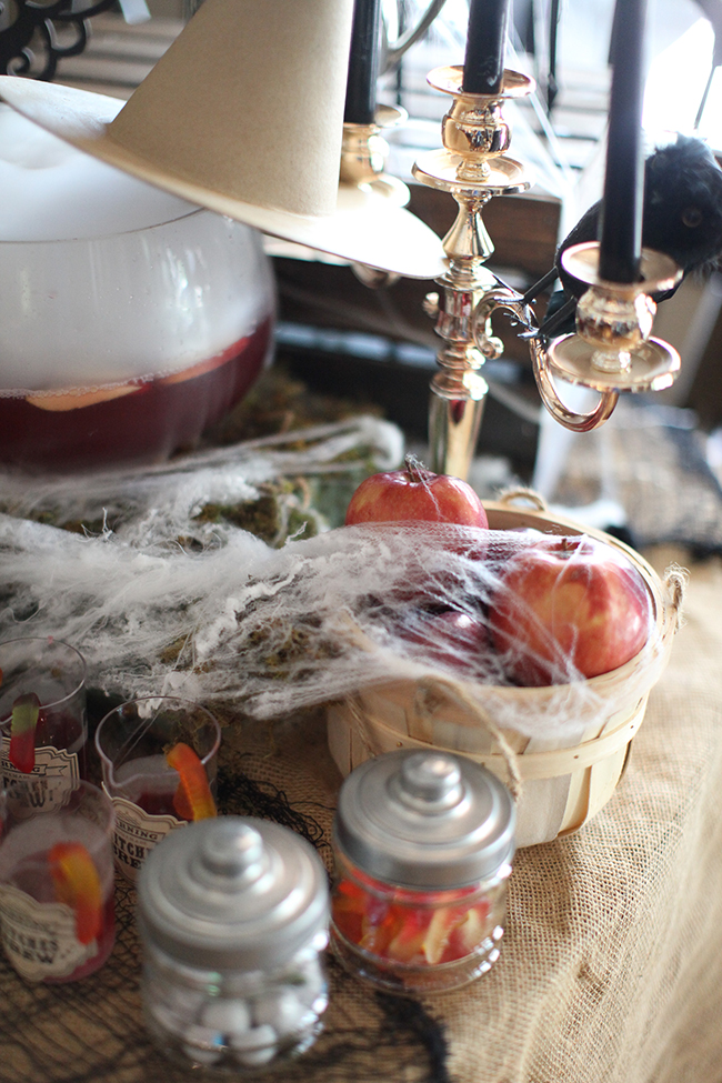 Black pillar candles, apples with cobwebs, and spooky treats are served at this Evil Queen Party!