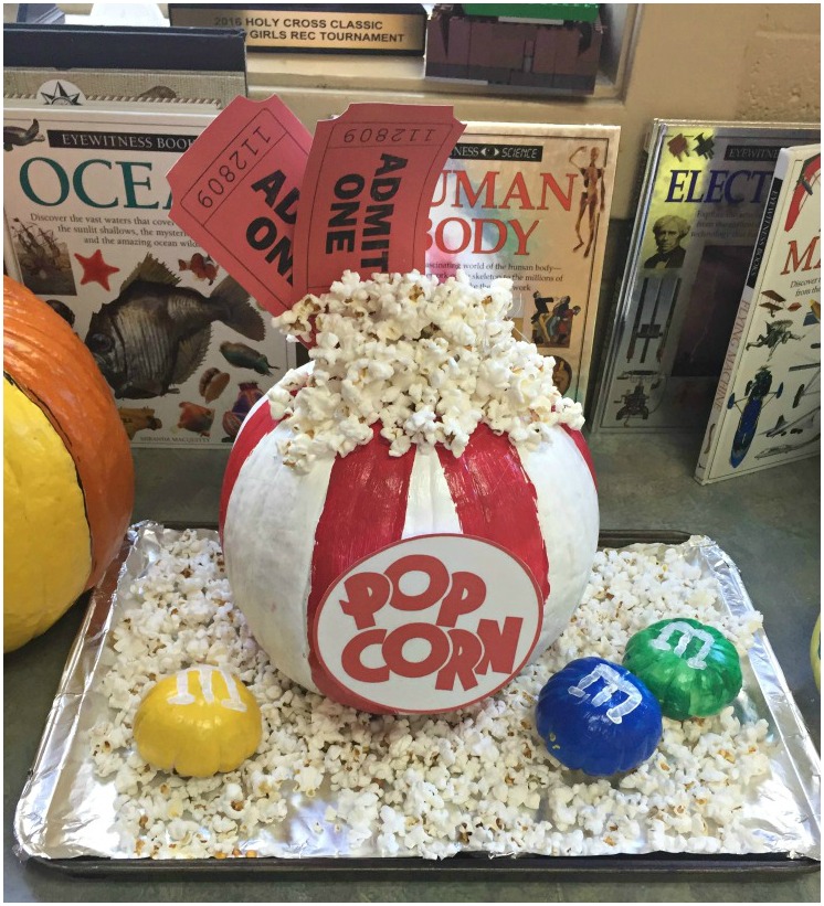 No carve pumpkin decorating - love this pumpkin painted like a bag of popcorn, complete with movie tickets and miniature pumpkins painted like M&M's. 