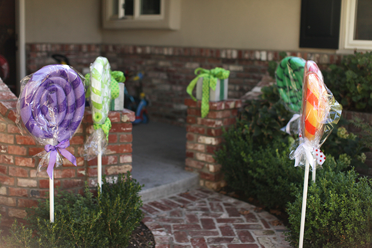 Transform your house into a gingerbread house for Christmas with these GIANT lollipops made with pool noodles. They are super cute and very easy to make! Easy Christmas decor DIY.
