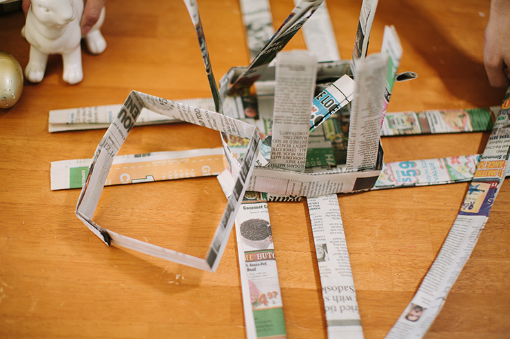 Fold the base strips up around the square to form a basket with newspaper.