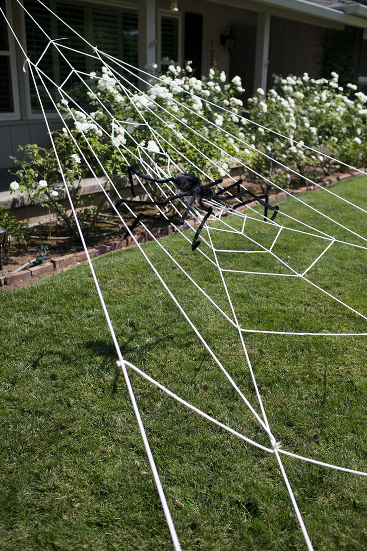 Laundry line and zip ties are all you need to make a giant spider web Halloween decoration.