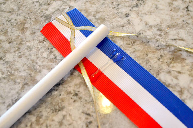 Use hot glue to attach your ribbons to the wooden dowel. 