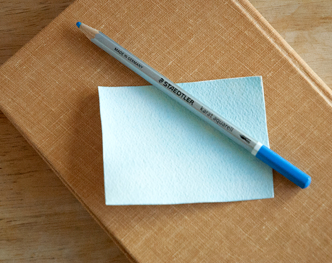 Lightly color a pice of watercolor paper for the background for your book page art. 