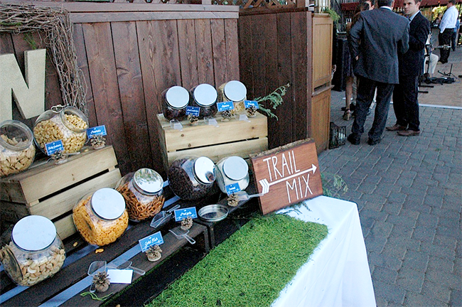 Trail mix bar! Great idea for an outdoor wedding. Love the moss on the table and the pinecone sign holders. 