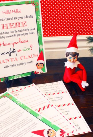 Elf on the Shelf sitting by printable letters and cards with a Christmas tree.