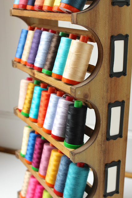 Turn a wine rack into a thread holder.