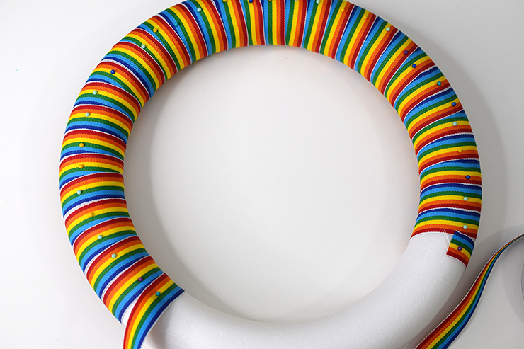 Wreath form with rainbow ribbon wrapped around it for a St. Patrick's Day wreath.
