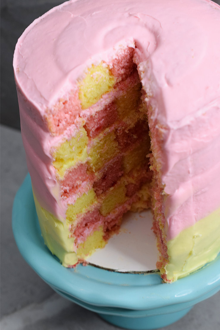 Pink and yellow cake on a teal plate.