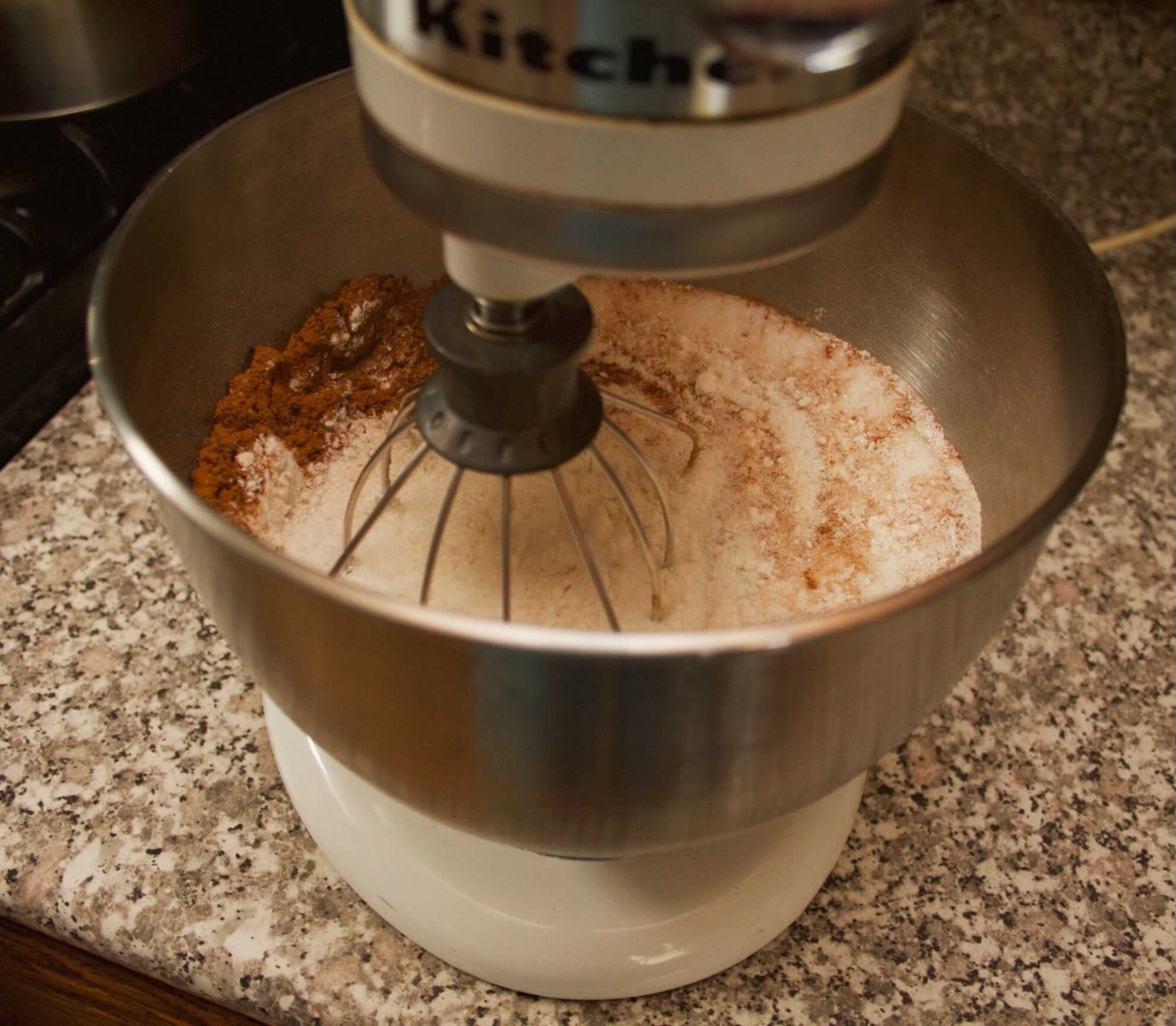 Dry pumpkin bread ingredients in a stand mixer.