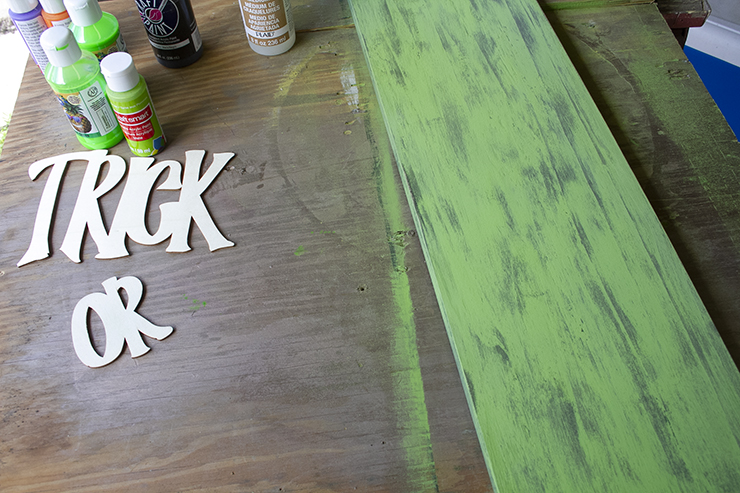 Board painted bright green, and then sanded, to reveal the black paint below.