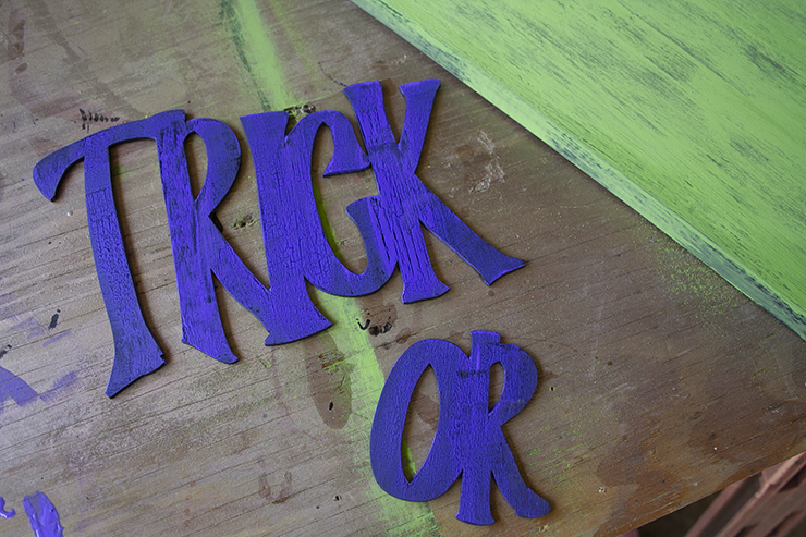 Purple 'trick or' words painted with crackle paint to allow the black paint below to show through.