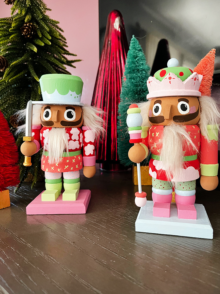 Painted nutcrackers with pink, green, blue, and red accents. 