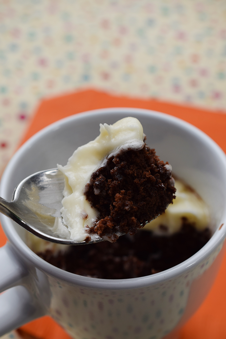 Spoonful of mug cake with homemade frosting.