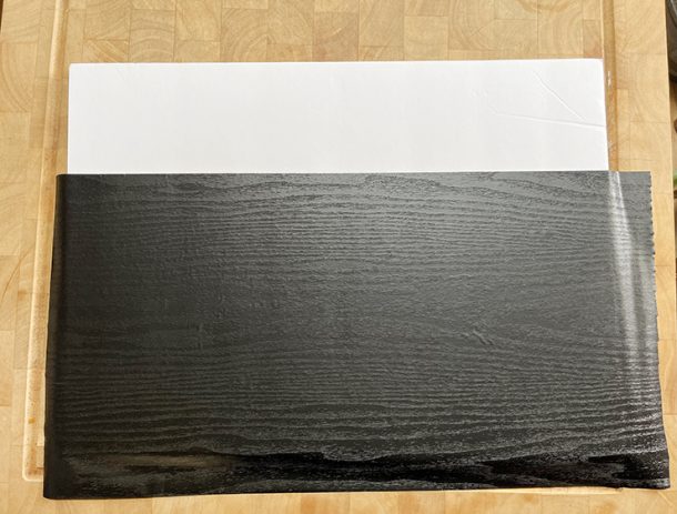 Piece of foam board with black, wood-grain contact paper on top to make a photography backdrop.