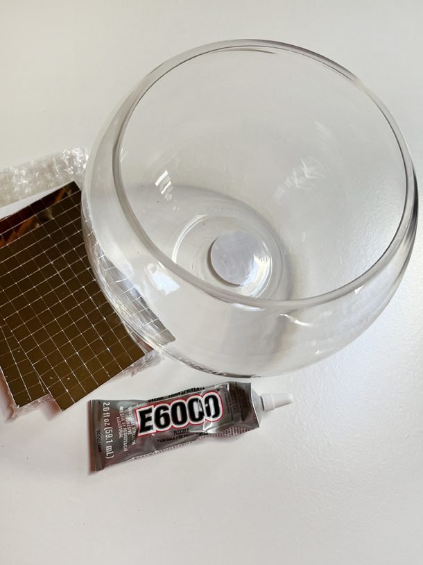 Materials to make a disco ball planter - a glass bowl, mini square glass mirrors, and E6000 glue.