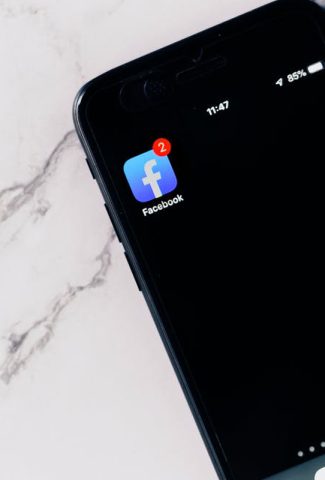 Picture of a phone with the Facebook app icon.