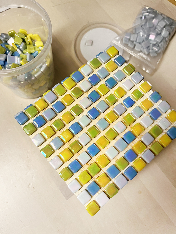 Wooden tissue box with small mosaic tiles sitting on top in a pattern.