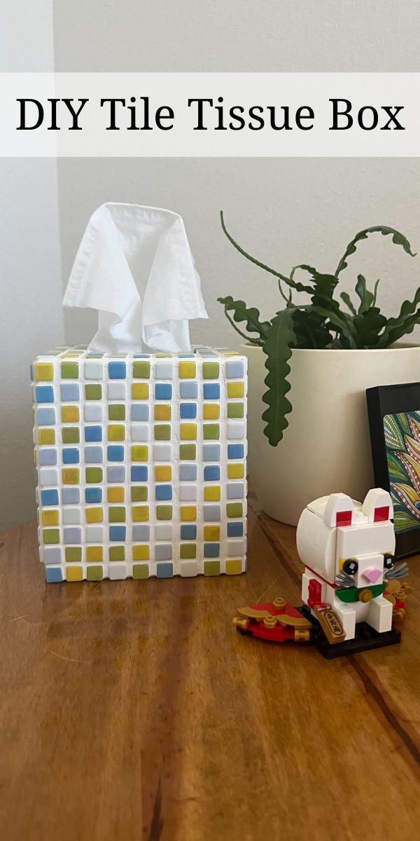Picture of a mosaic tile tissue box with green, blue, and yellow tiles and the label DIY tile tissue box at the top of the image.
