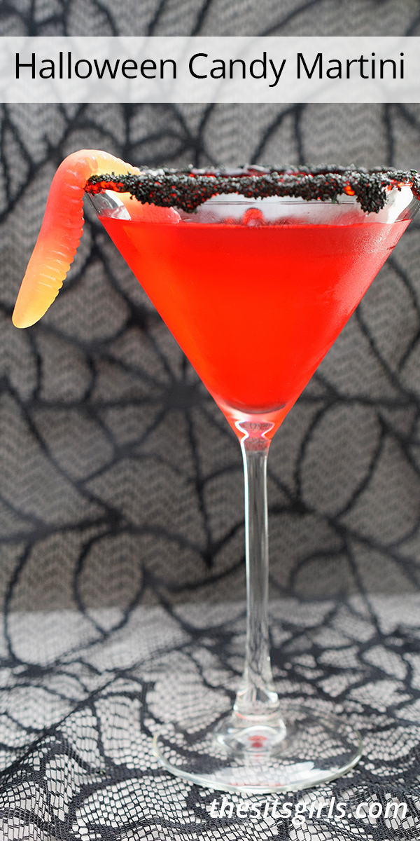 Halloween Candy Martini - picture of a martini glass with a bright red drink, black sprinkles on the rim, and a gummy work garnish on the side.