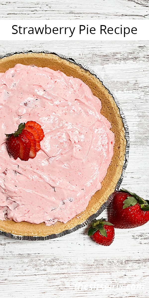 Strawberry pie with real strawberries sitting next to it on a wooden table.