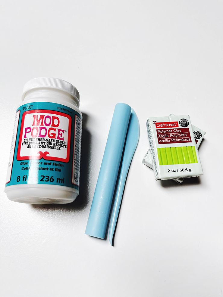 Materials for a splat spoon rest, mod podge, bright green polymer clay, and a clay tool set.