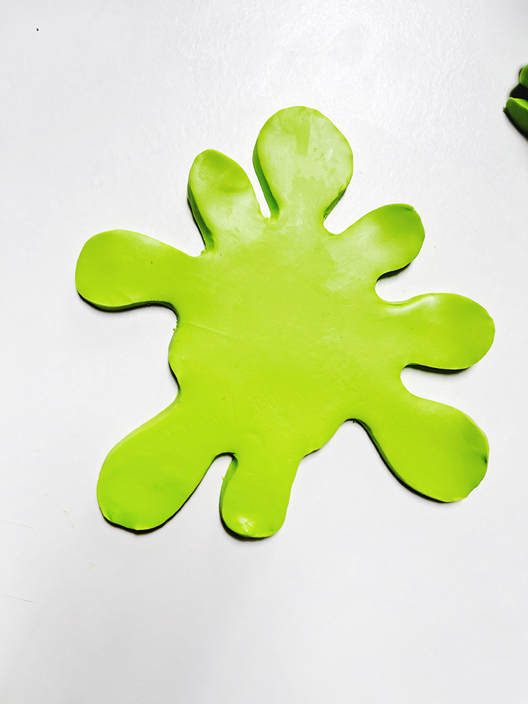Bright green clay cut out in a splat shape.
